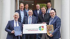Vertreter der betreffenden Kommunen und weitere Beteiligte posieren vor der Kamera für ein Foto
